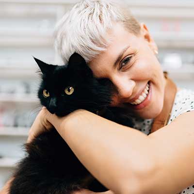 A woman holding a black cat A woman holding a black cat