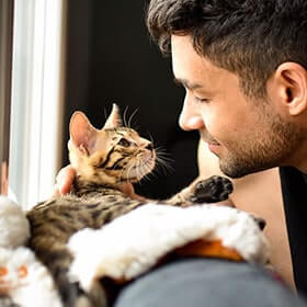 A man cuddling with his cat A man cuddling with his cat