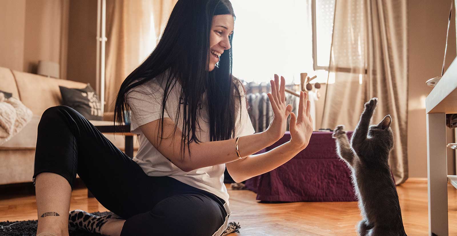 A woman playing with her kitten